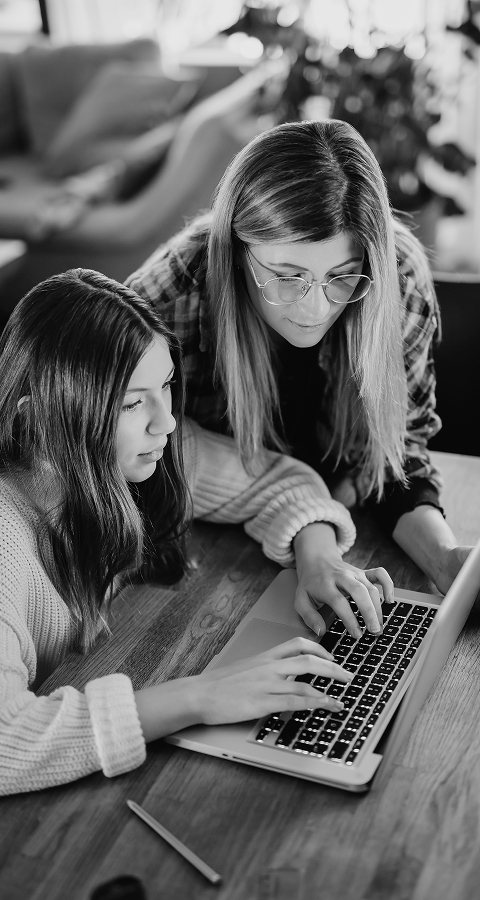 A woman and a girl learning together on a laptop, representing YouR Star's software and music-therapy education